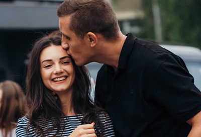 Man kissing woman on forehead